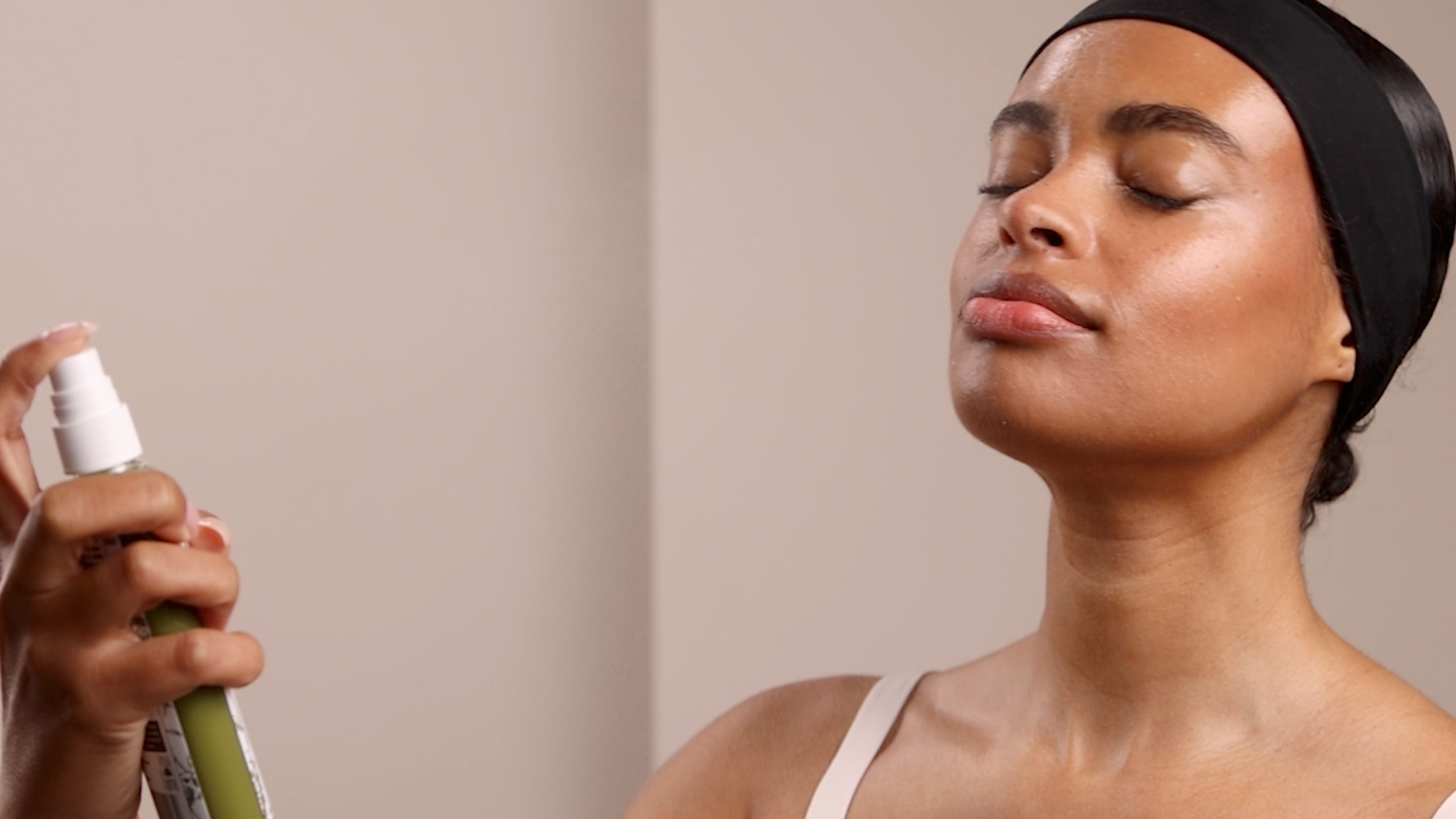A woman spraying the Eminence Organics Stone Crop Hydrating Mist to her face