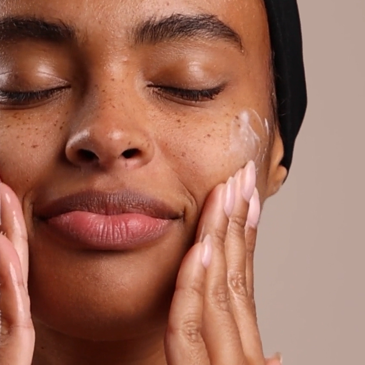 A woman applying Eminence Organics Calm Skin Chamomile Cleanser to face
