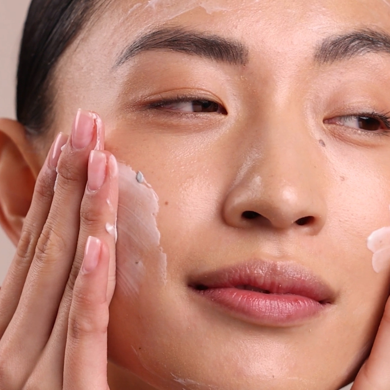 A woman applying Eminence Organics Clear Skin Probiotic Masque to face