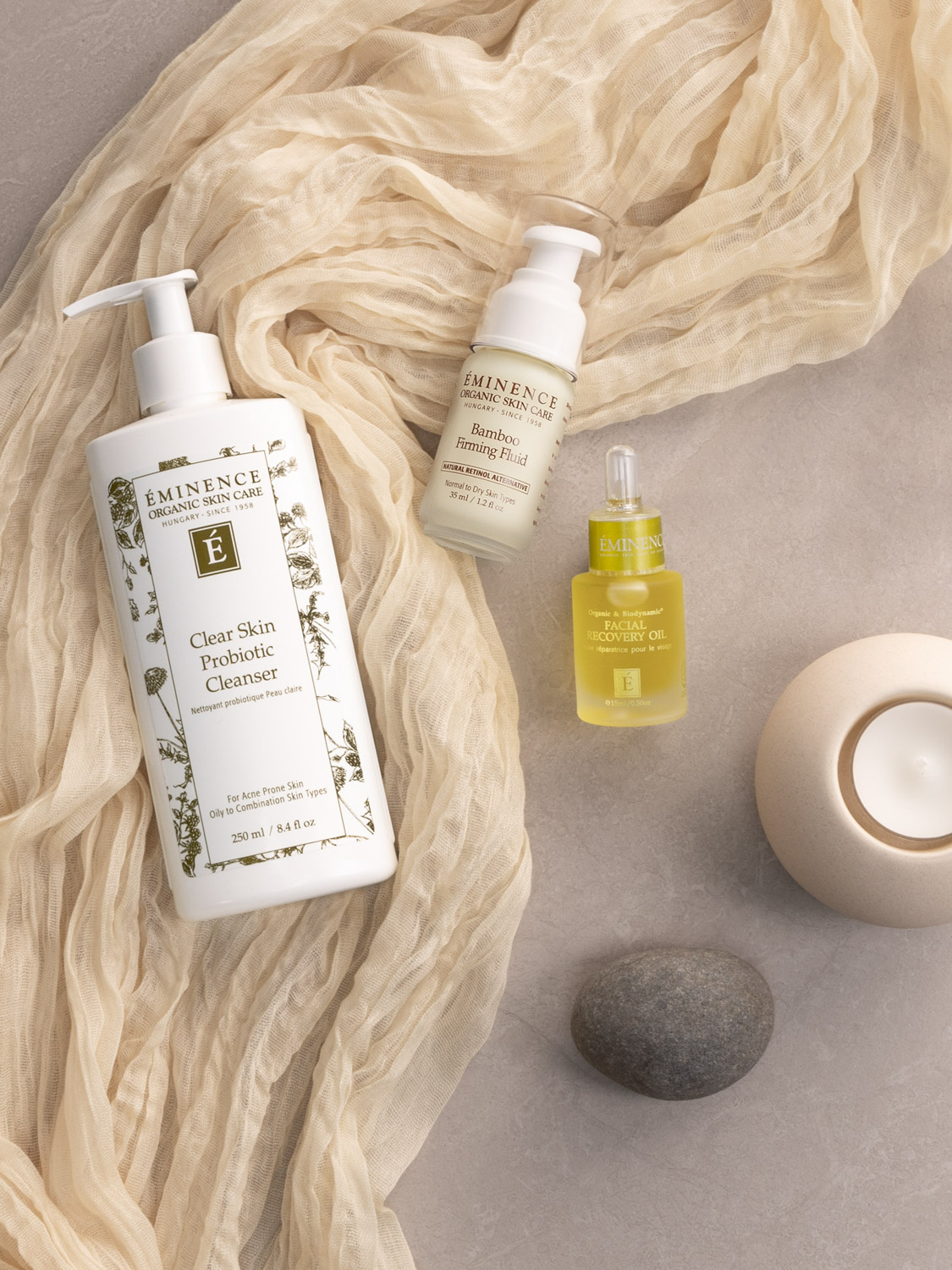 3 Eminence Organics products laid out on top of a slik scarf