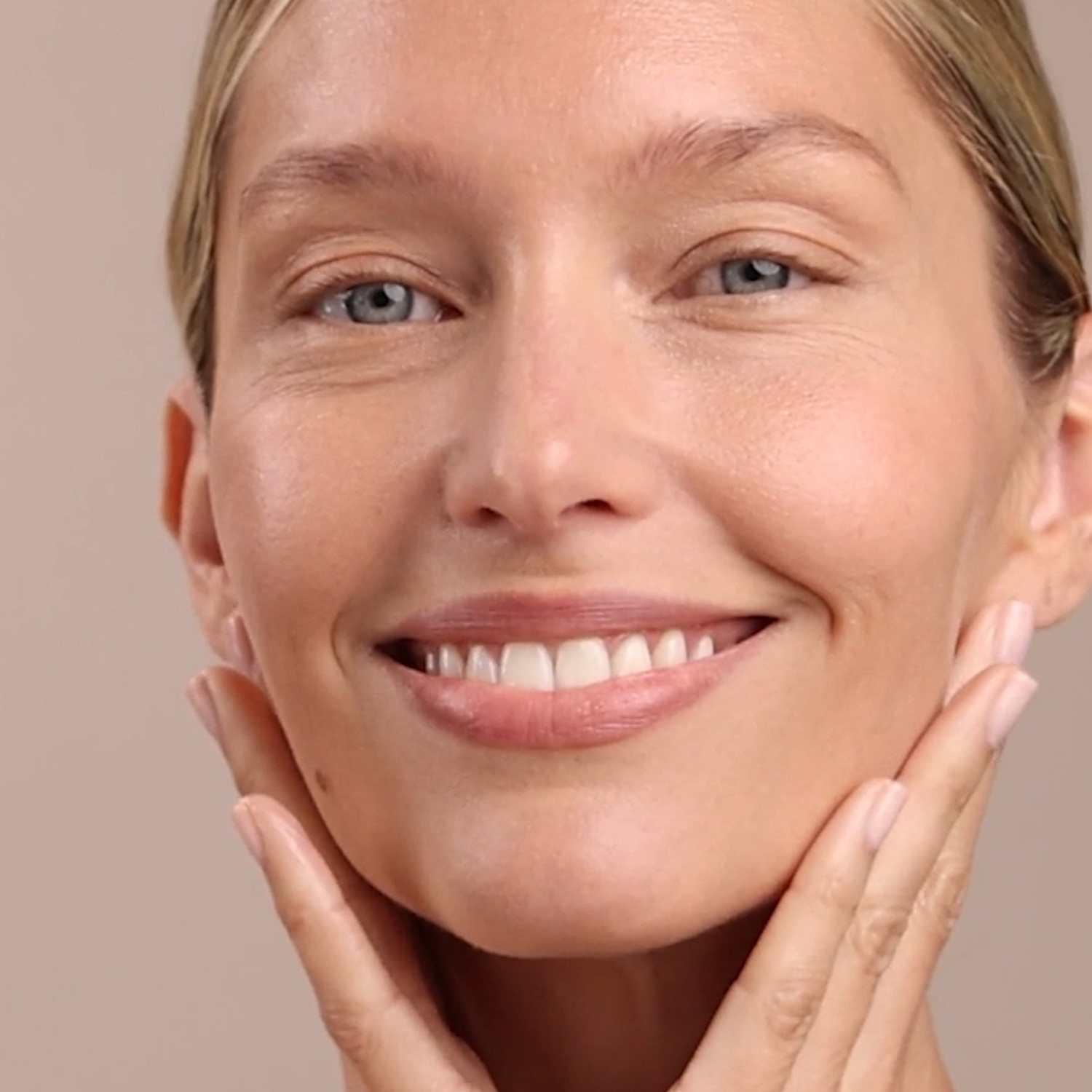 A woman applying the Eminence Organics Lavender Age Corrective Night Concentrate on her face with both hands