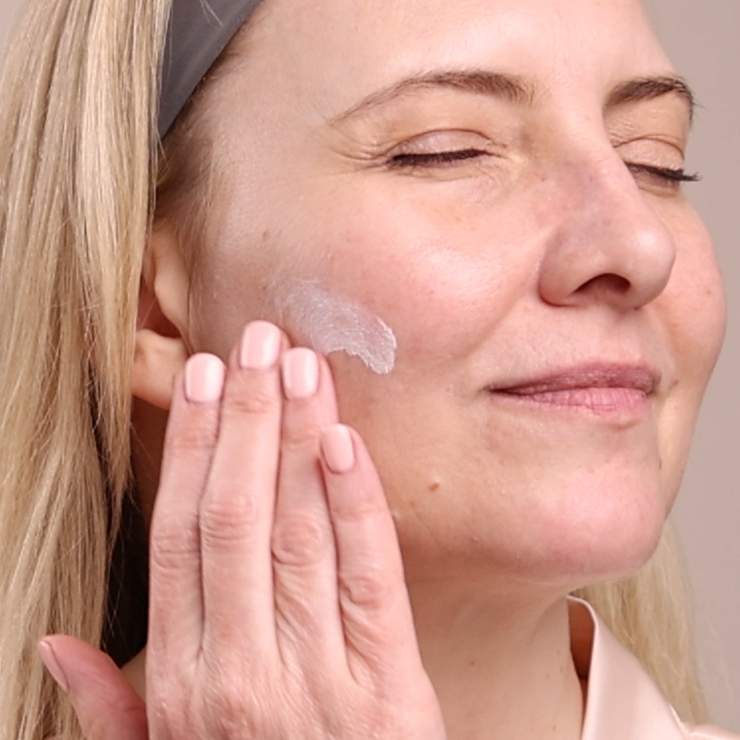 A woman applying the Eminence Organics Lilikoi Daily Defense Moisturizer SPF 40 on her face