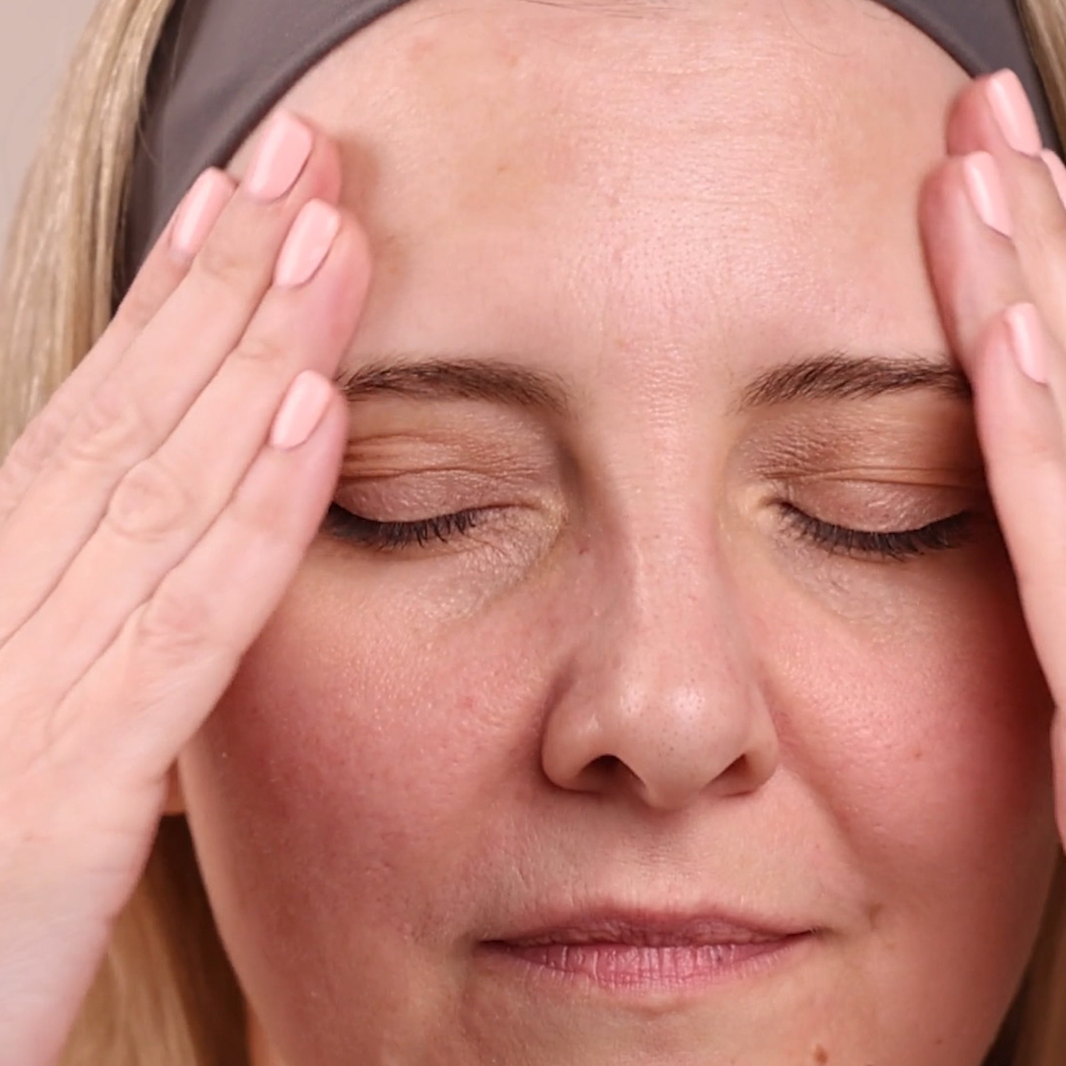 A woman applying Eminence Organics Bright Skin Licorice Root Booster-Serum to face