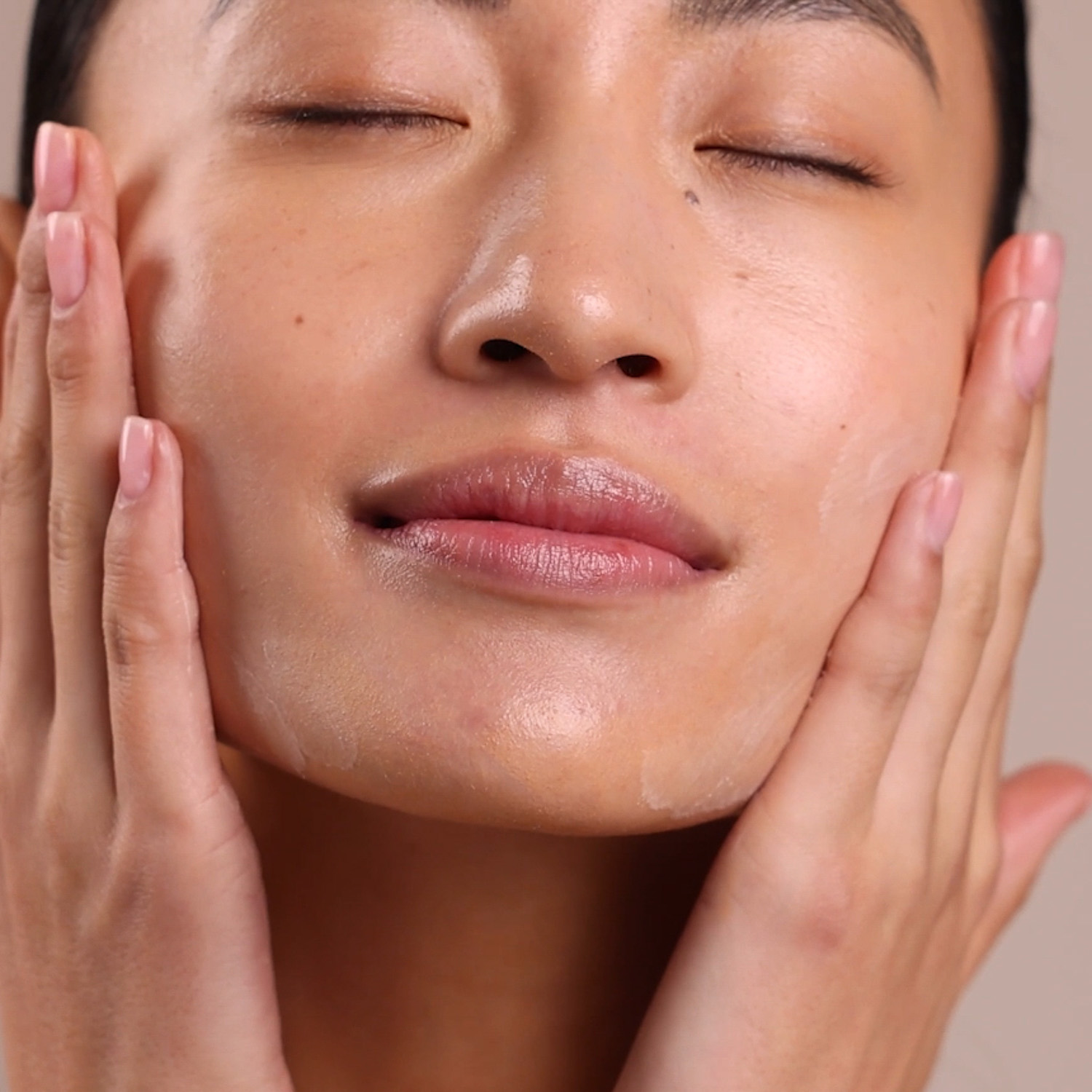 A woman applying the Eminence Organics Mangosteen Gel Moisturizer onto their face