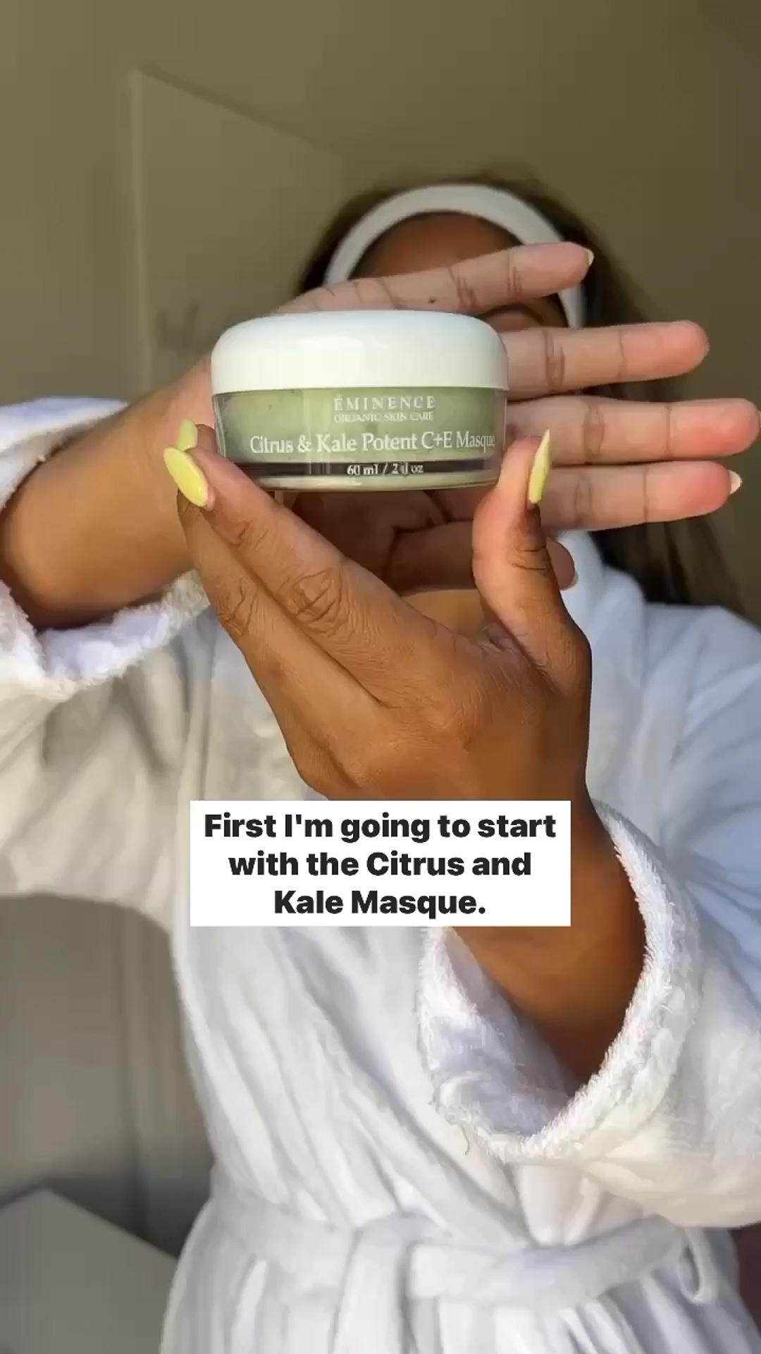 A woman holding Eminence Organics Citrus & Kale Potent C+E Serum