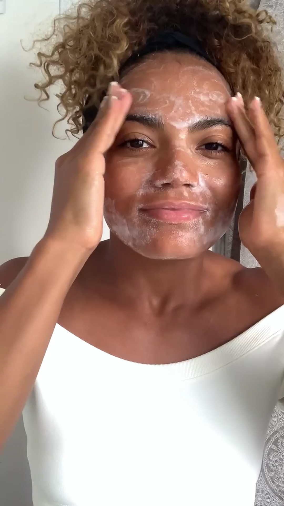 Woman cleansing face with Eminence Organics Clear Skin Probiotic Cleanser