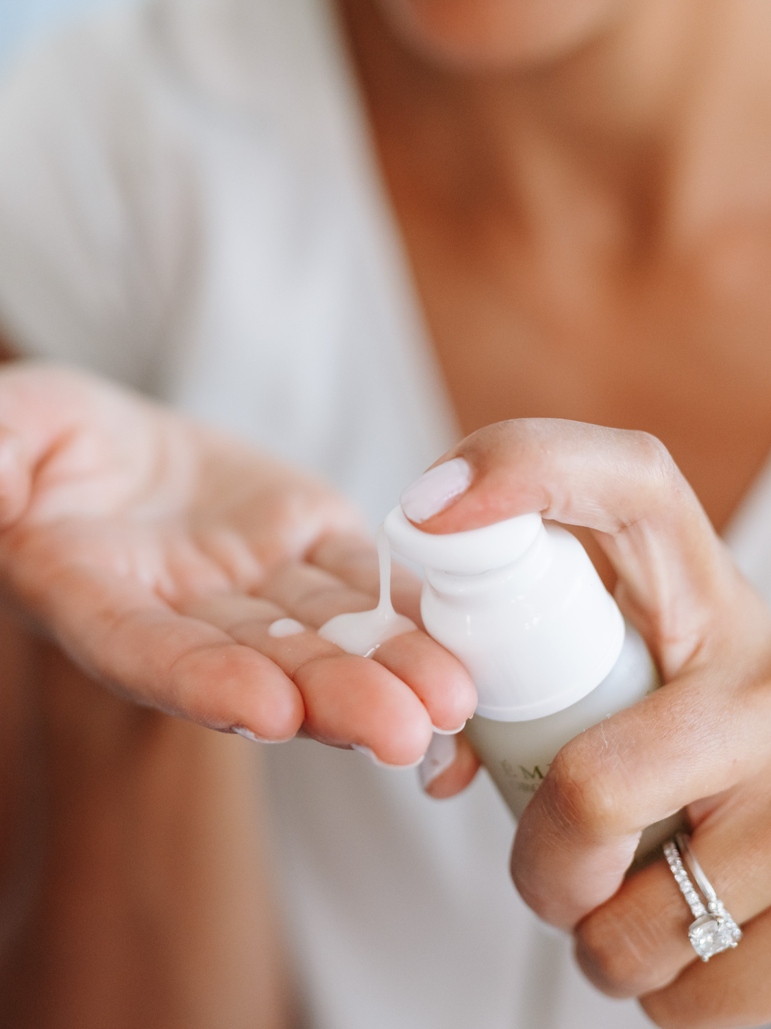 A woman applying Eminence Organics Acne Advanced 3-Step Treatment System on hand