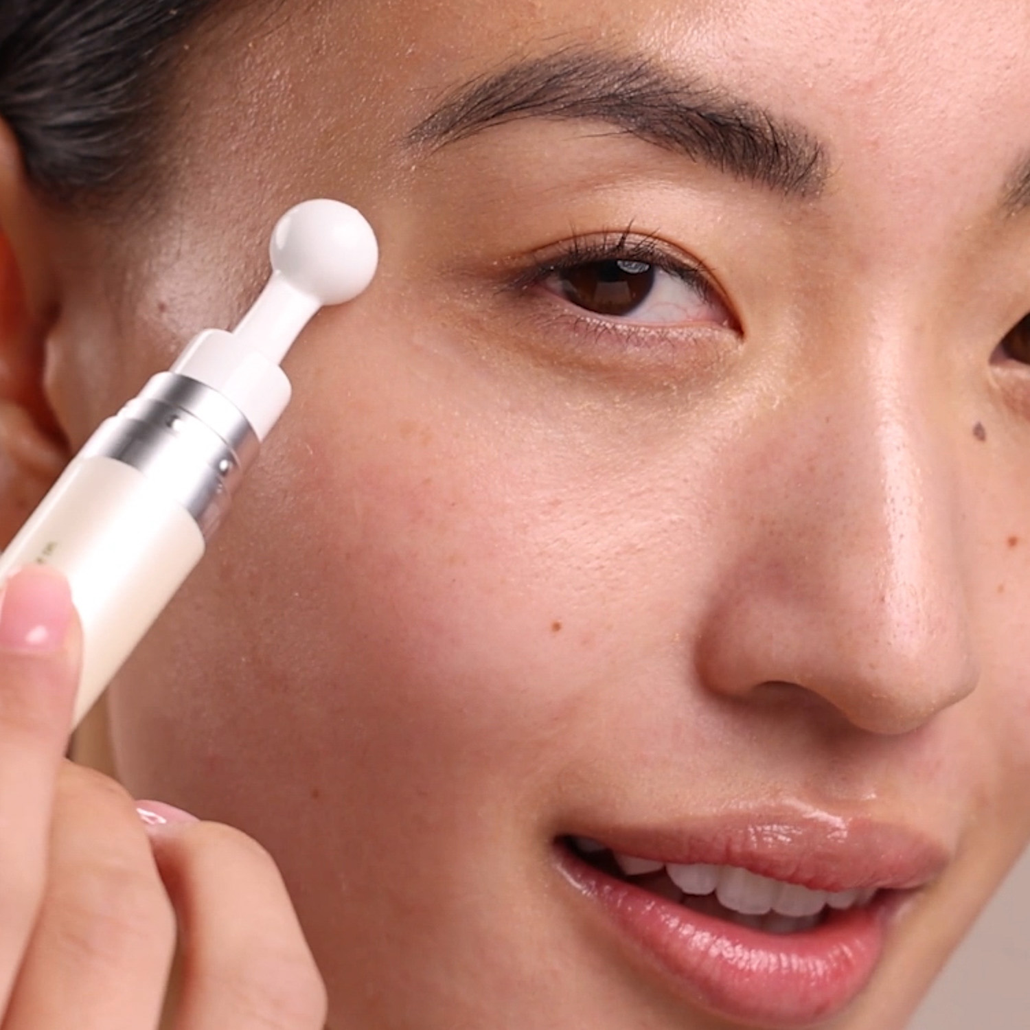 A close up of a woman applying the Eminence Organics Hibiscus Ultra Lift Eye Cream to the eye area
