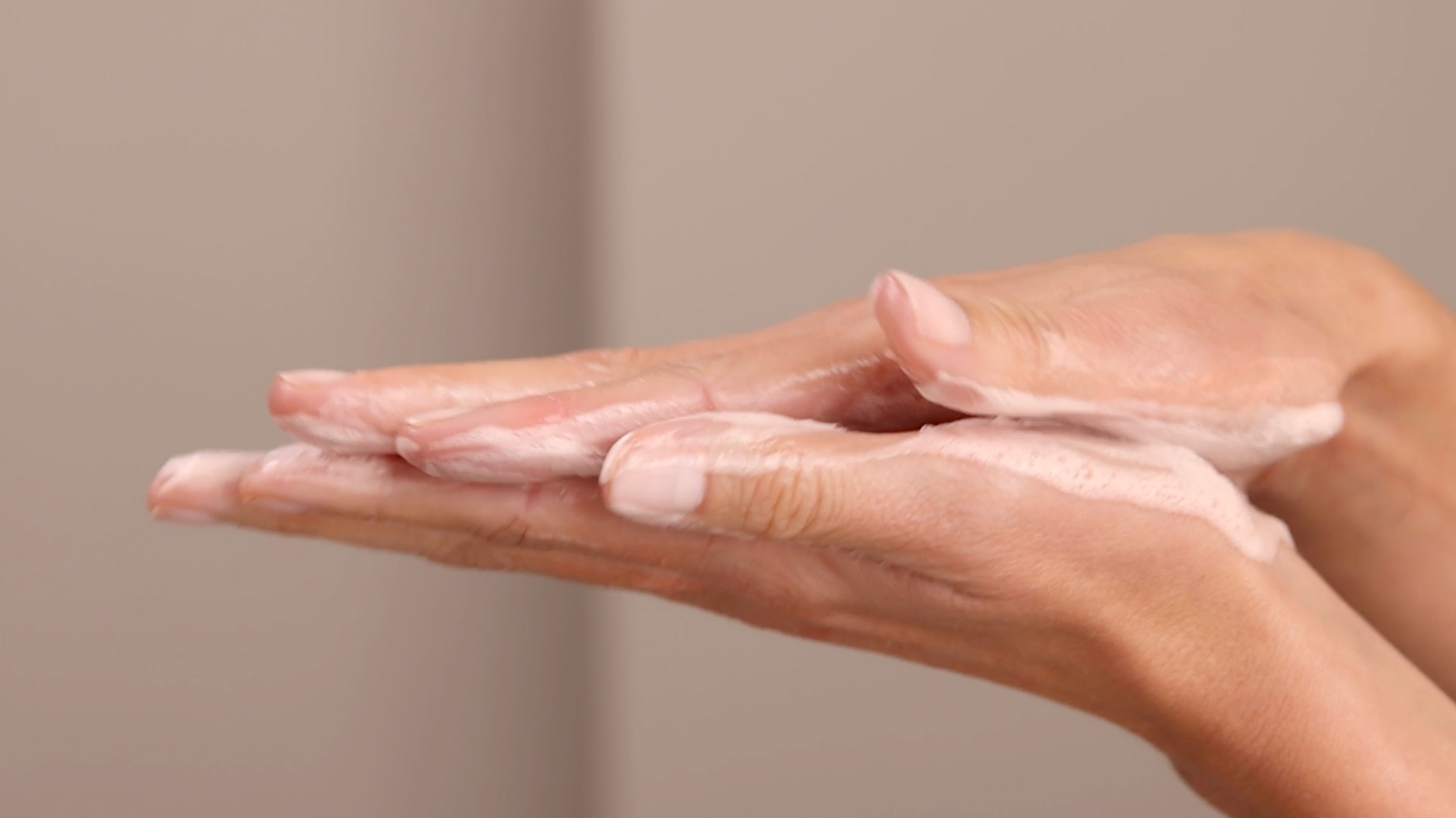 Hands applying Eminence Organics Barbados Cherry Enzyme Cleansing Powder