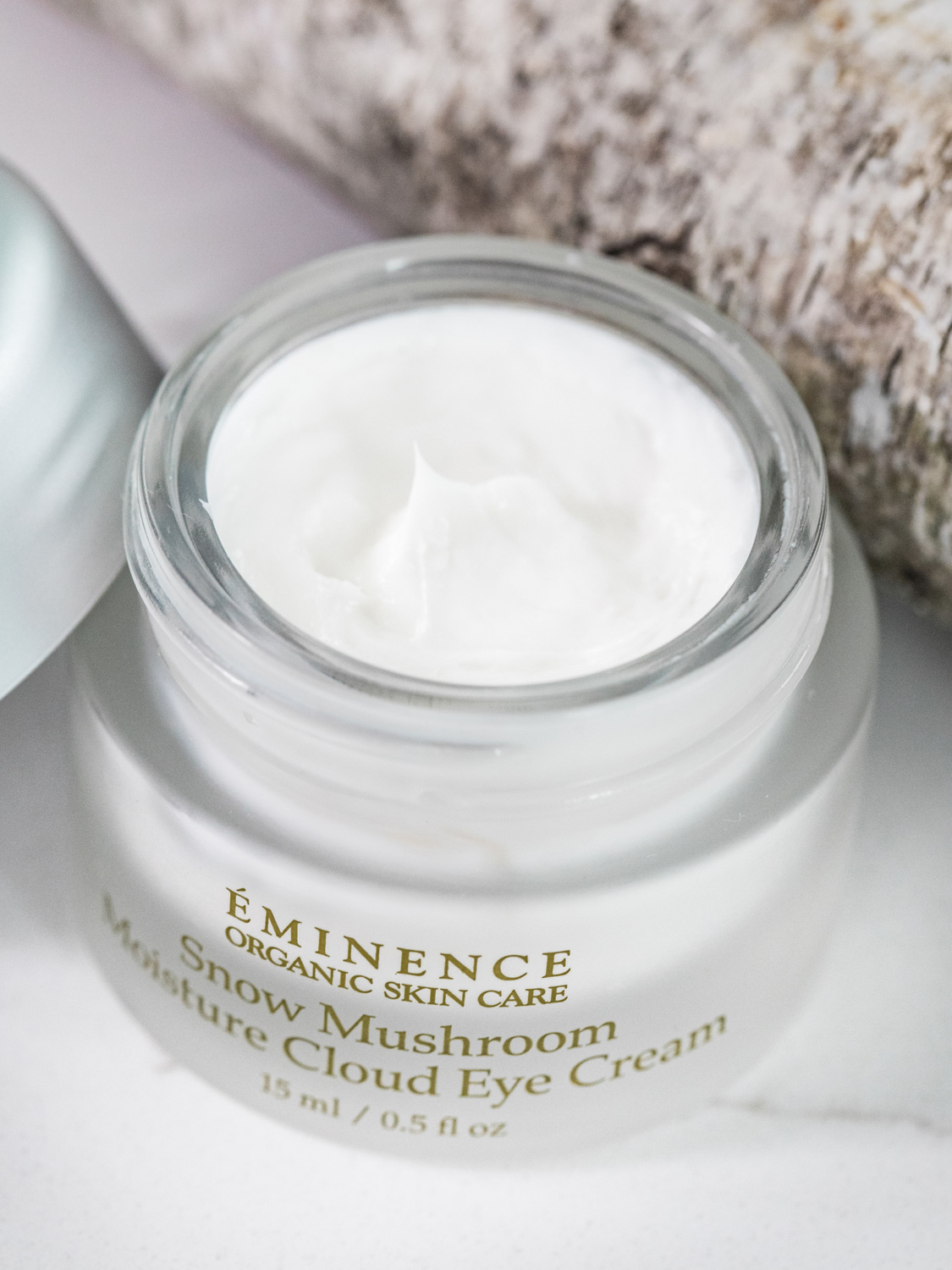 An open jar of the Eminence Organics Snow Mushroom Moisture Cloud Eye Cream