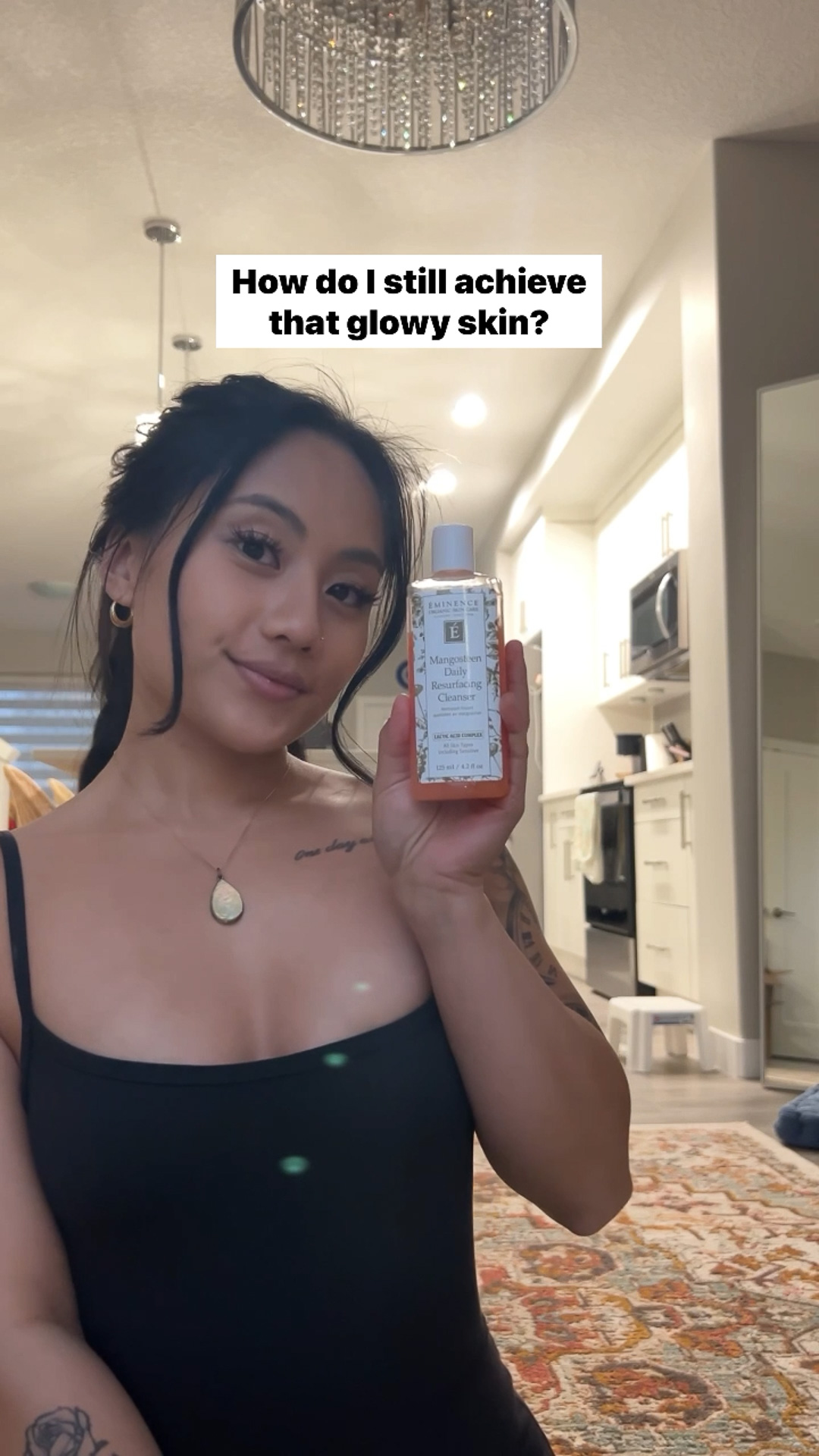 A woman applying the Eminence Organics Mangosteen Daily Resurfacing Cleanser to their face