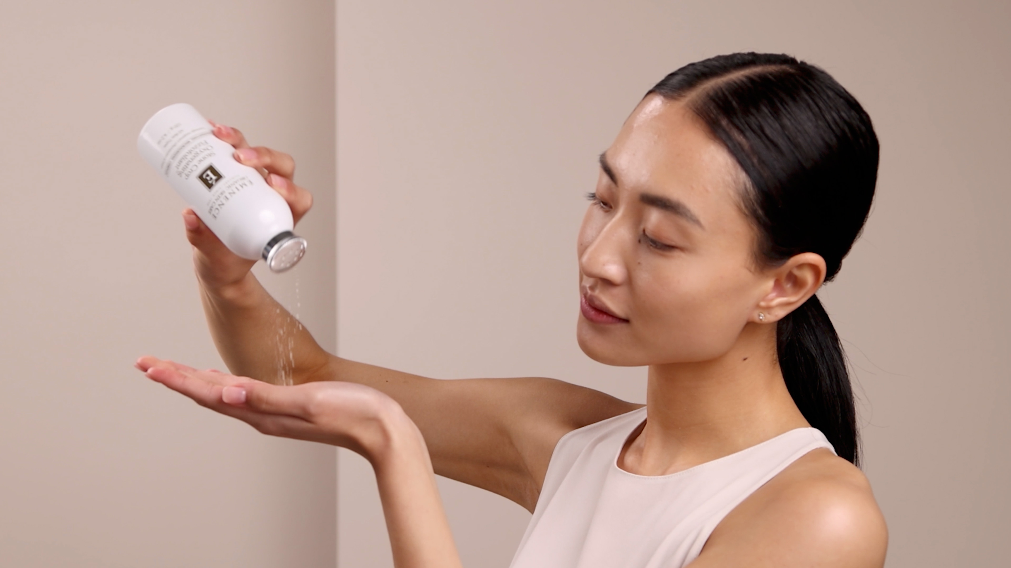 A woman pouring the Eminence Organics Stone Crop Oxygenating Fizzofoliant™ powder on her hand