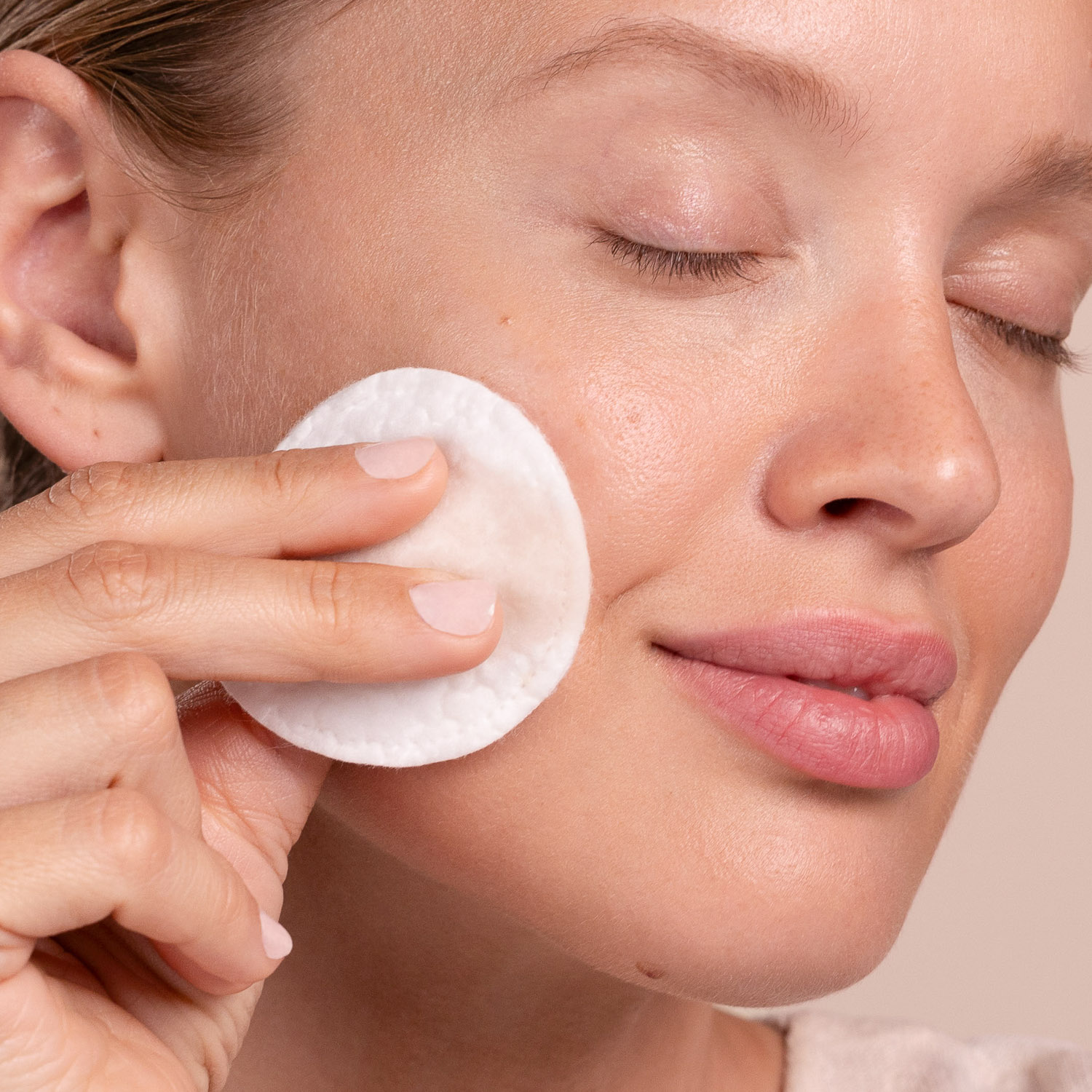 A woman applying Eminence Organics Clear Skin Willow Bark Exfoliating Peel to face