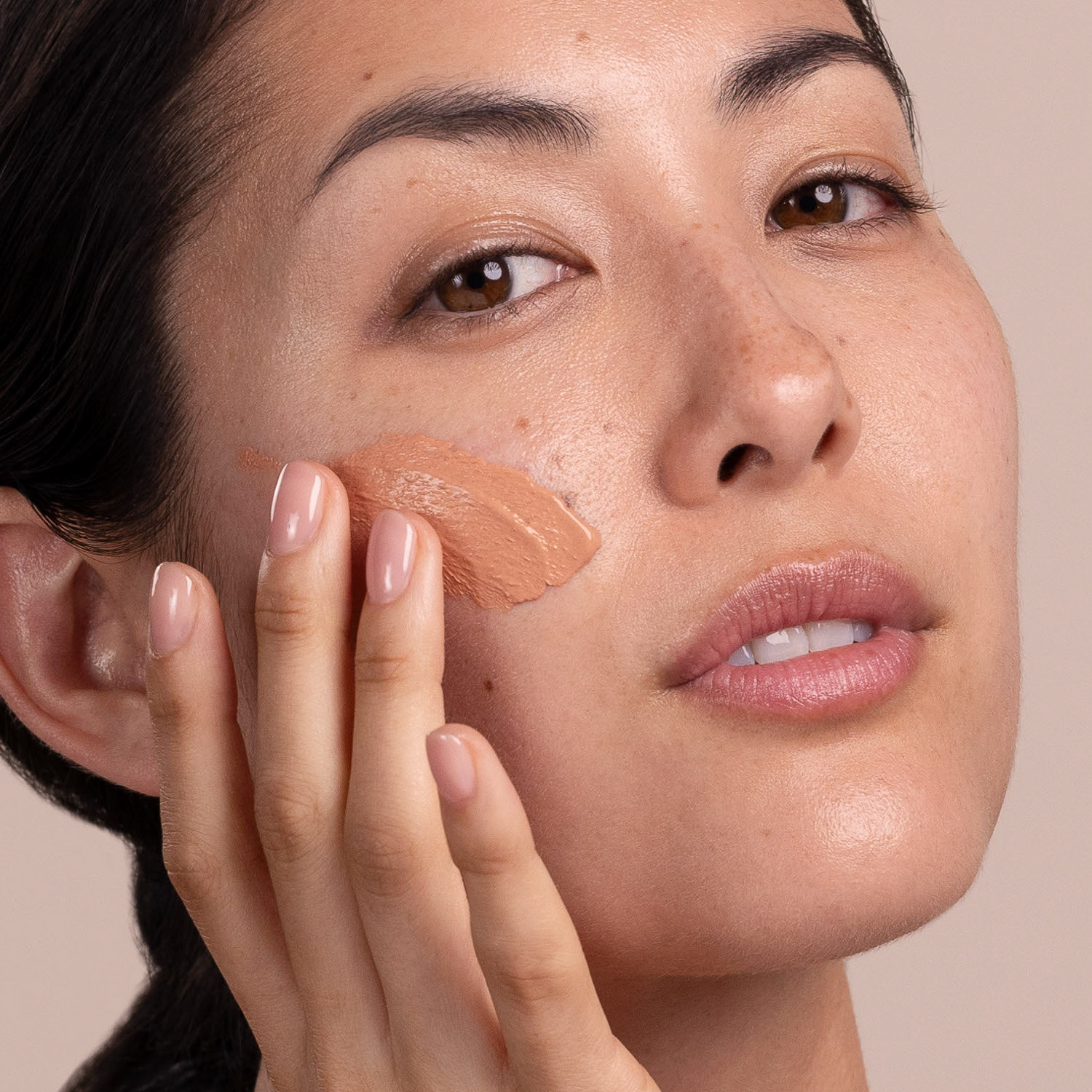 A woman applying Eminence Organics Acne Advanced Clarifying Masque on face