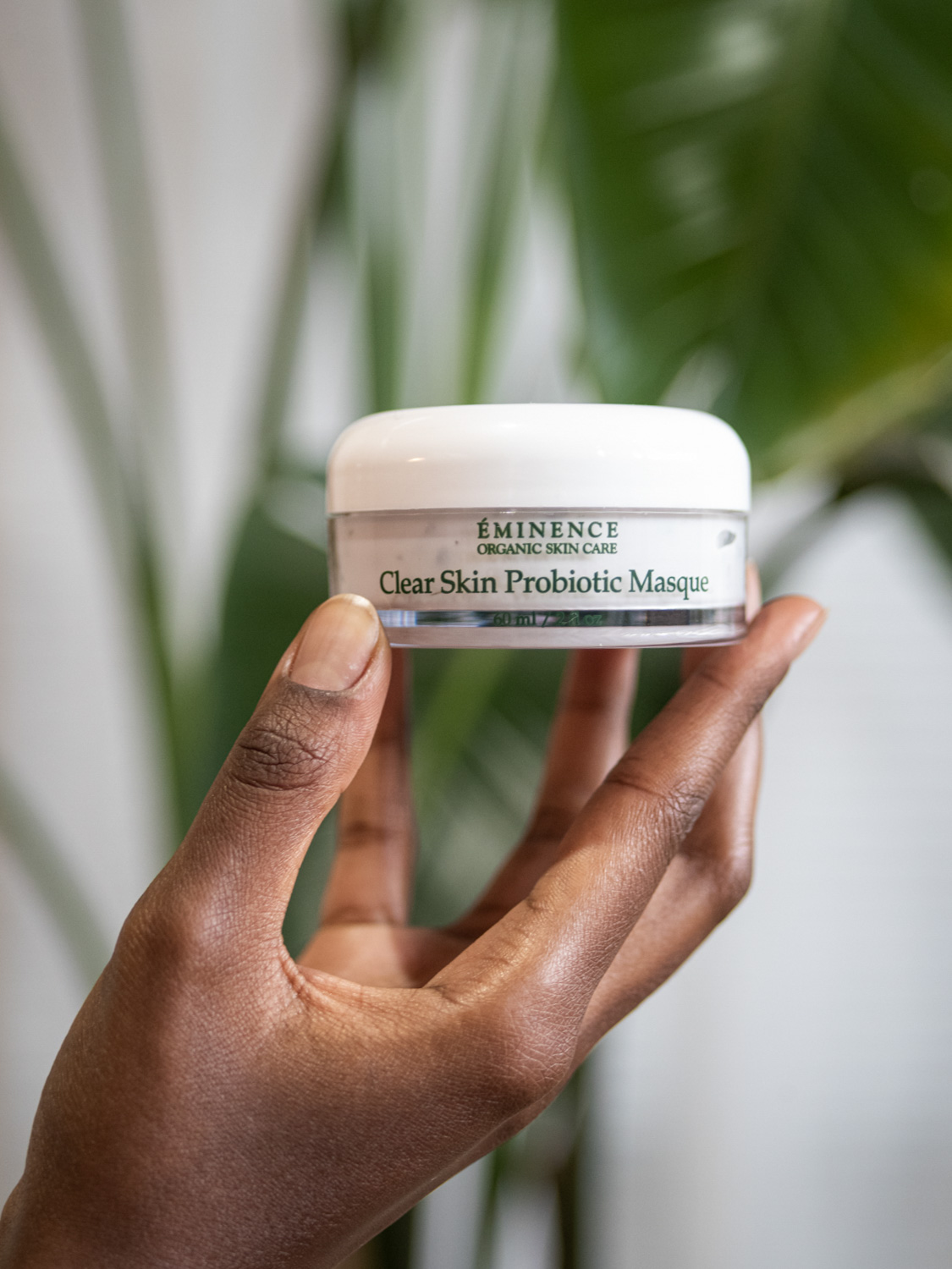 A woman holding Eminence Organics Clear Skin Probiotic Masque