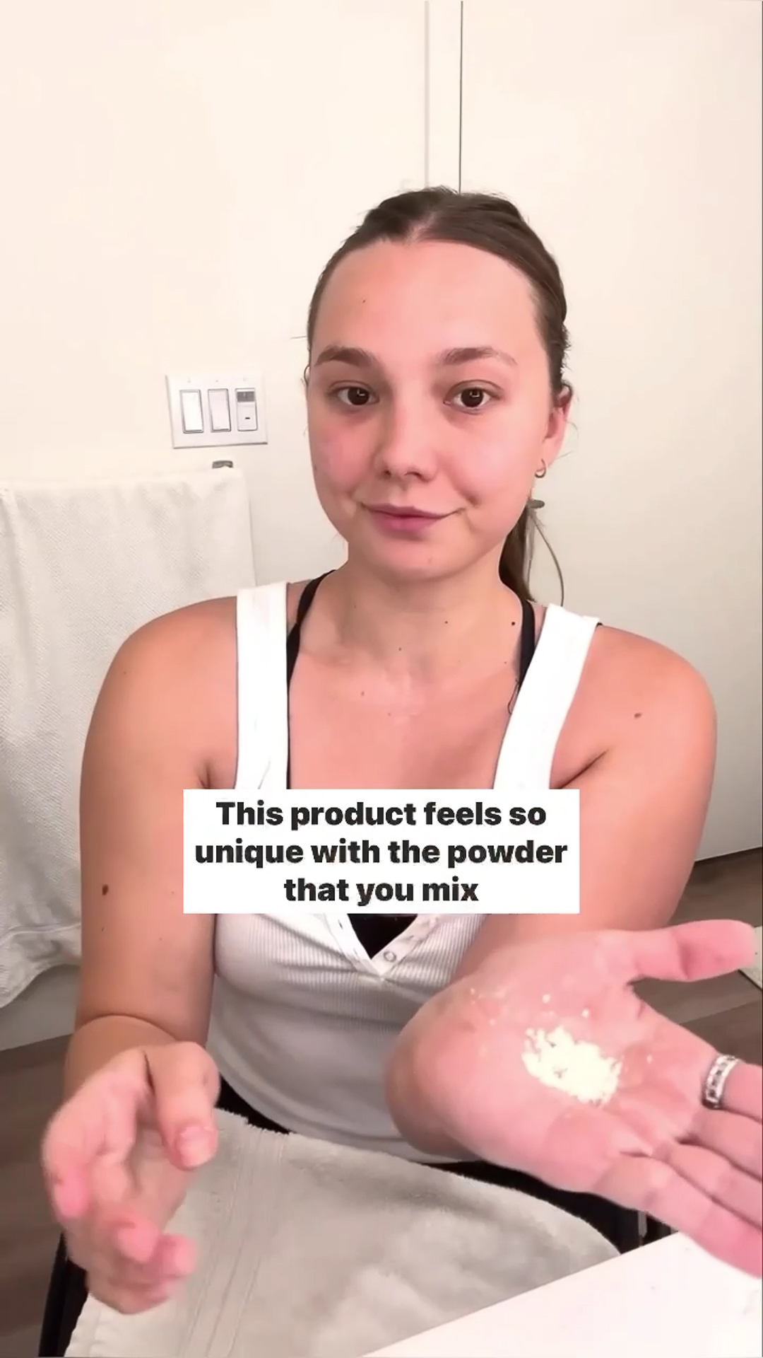 A woman showing her hand with a small amount of the Eminence Organics Strawberry Rhubarb Dermafoliant on it