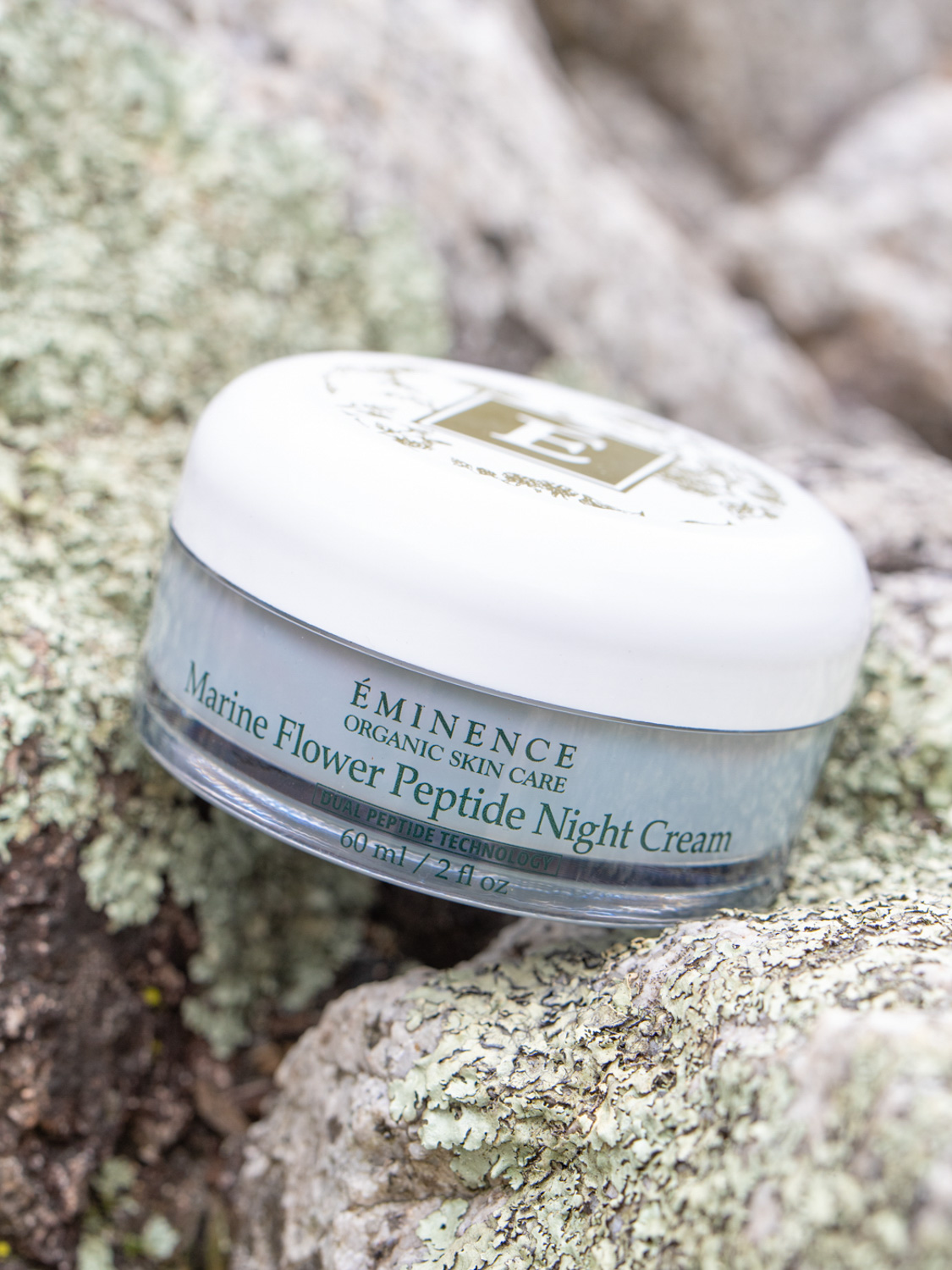 The Eminence Organics Marine Flower Peptide Night Cream Jar on stones next to the ocean