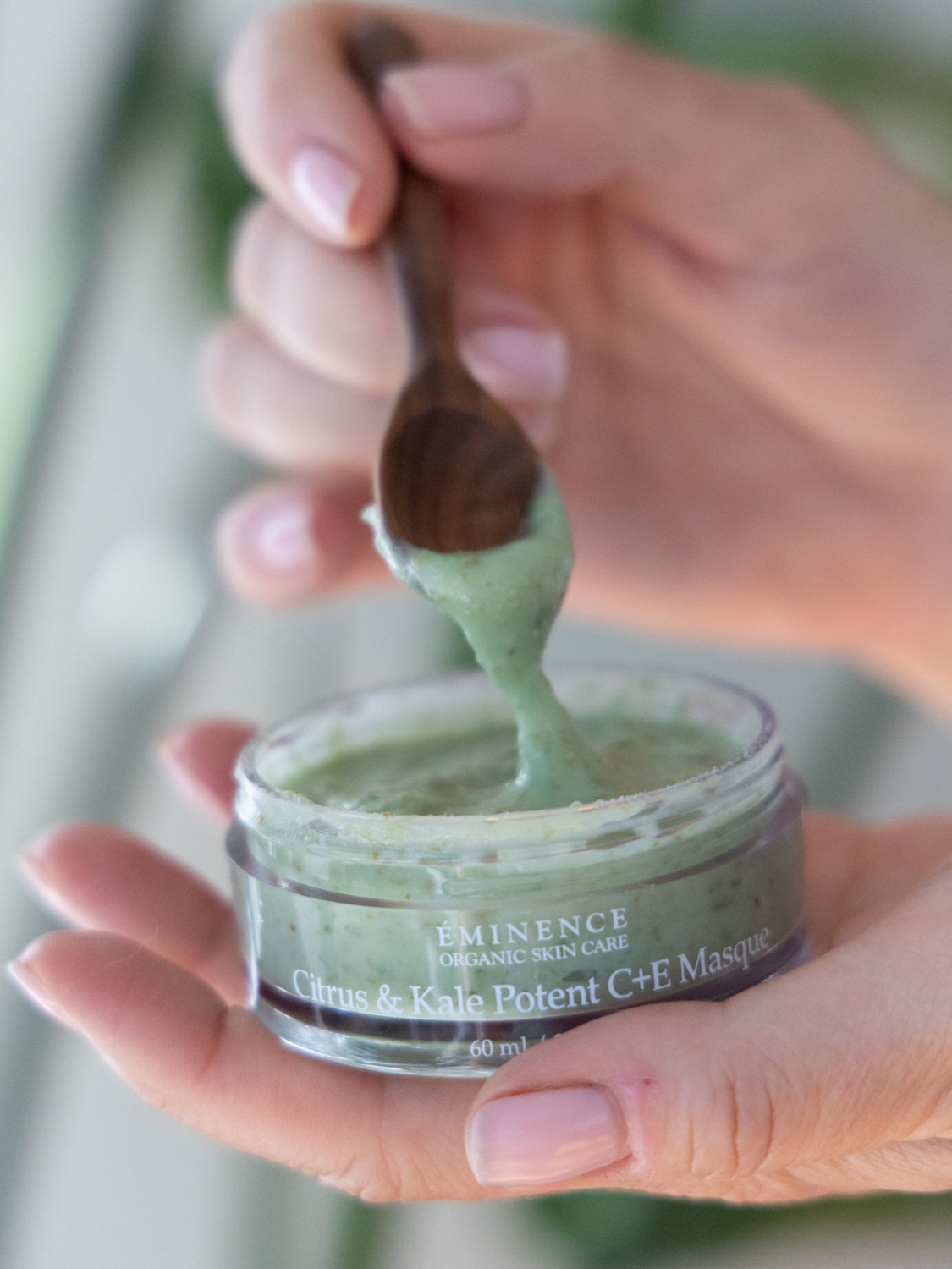 A woman holding Eminence Organics Citrus & Kale Potent C+E Serum