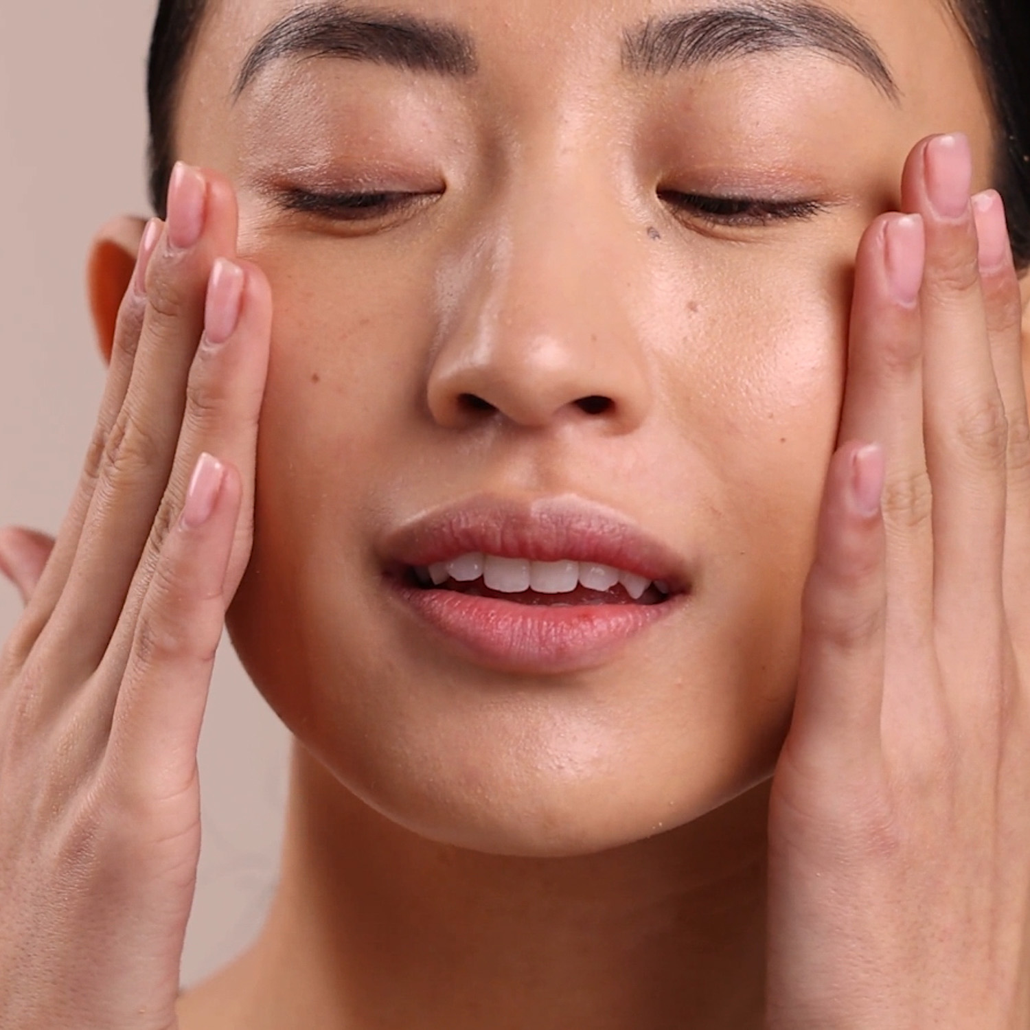 A woman applying the Eminence Organics Facial Recovery Oil onto her face