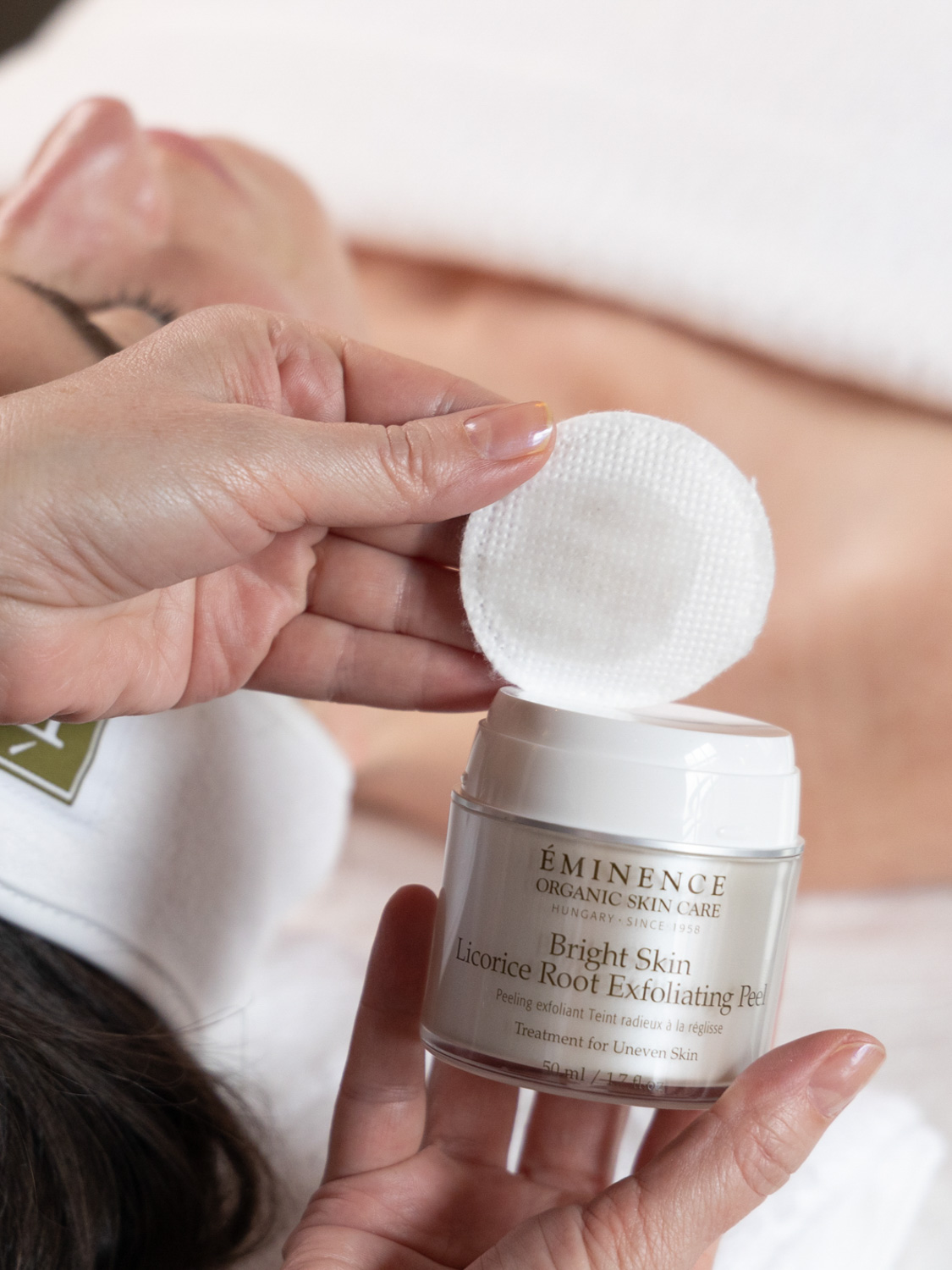 A woman holding Eminence Organics Bright Skin Licorice Root Exfoliating Peel