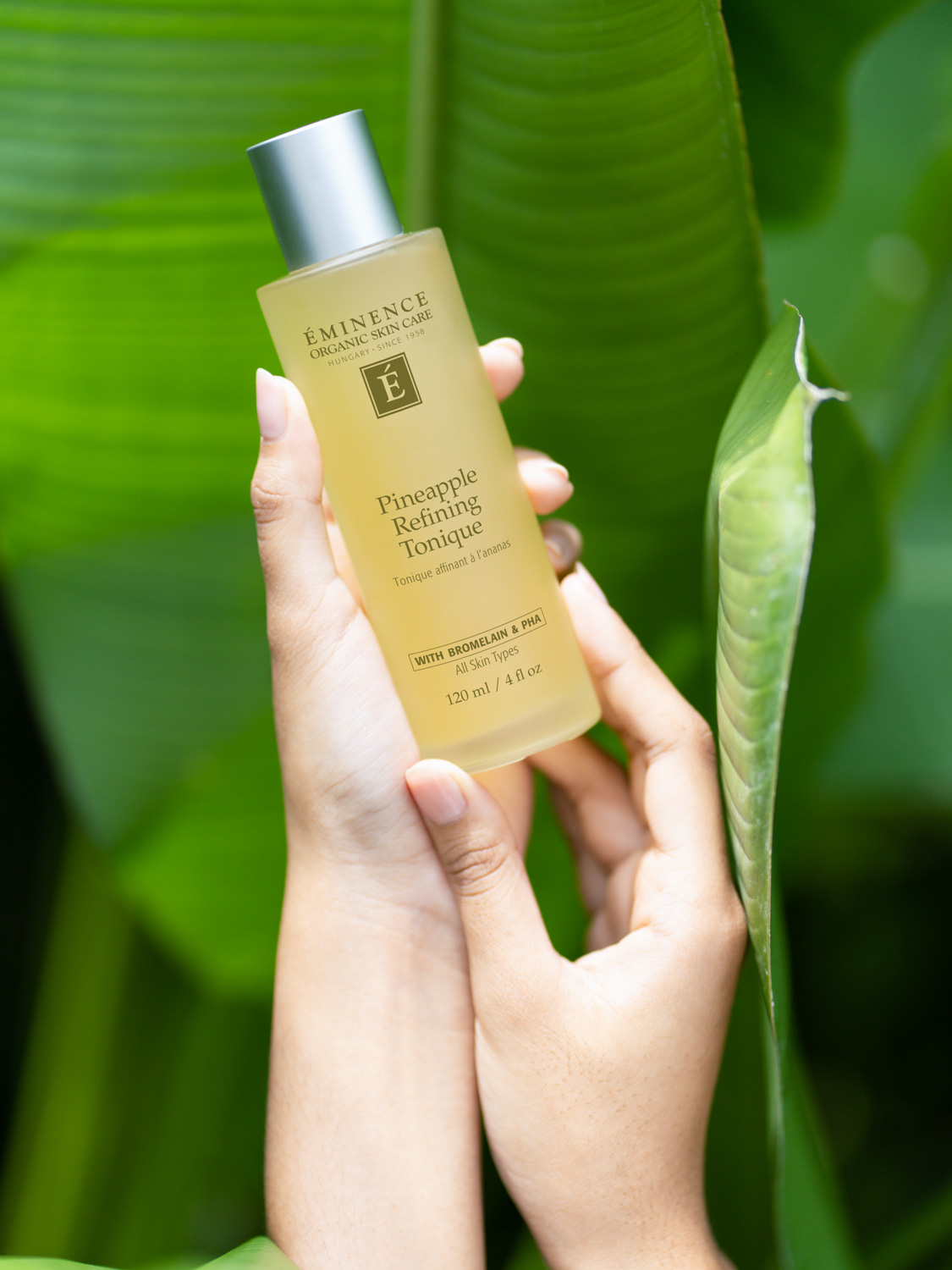 Hand holding the Eminence Organics Pineapple Refining Tonique