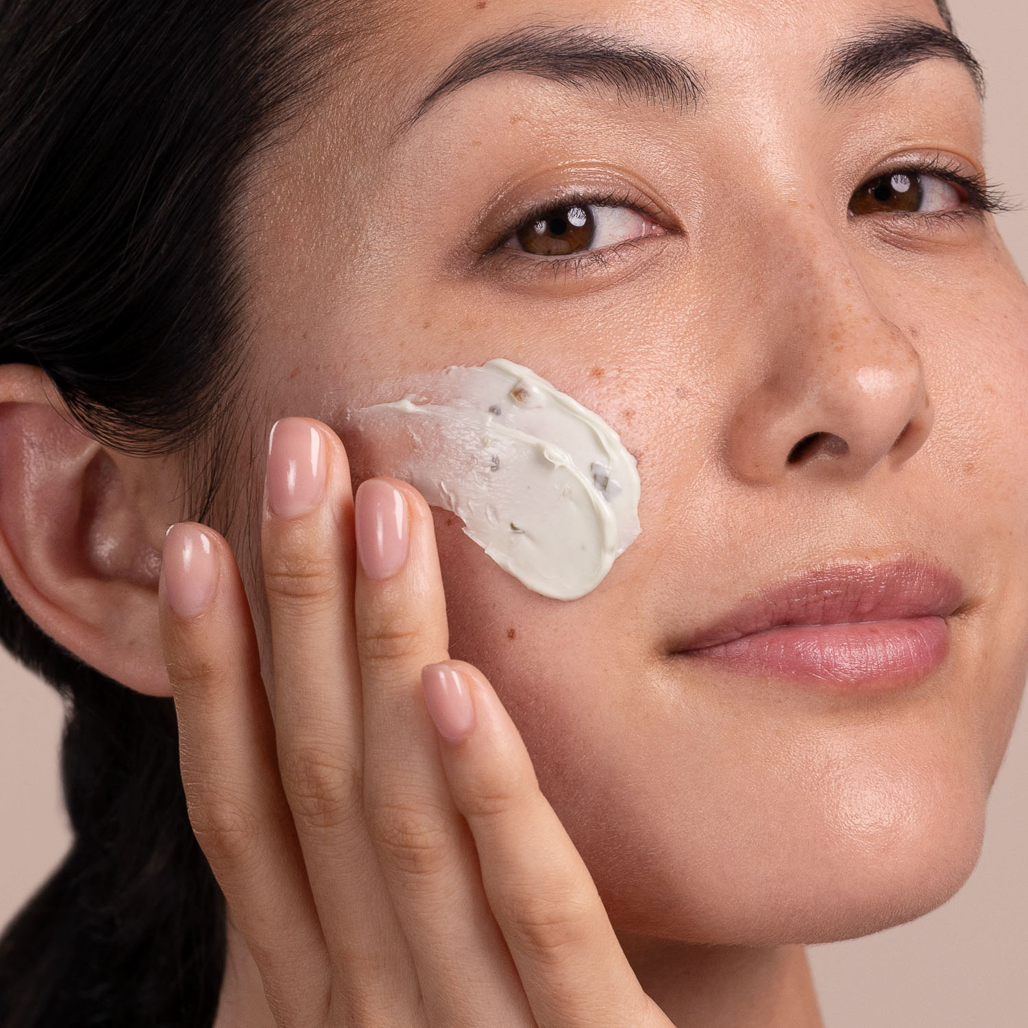 A woman applying Eminence Organics Bright Skin Masque to face