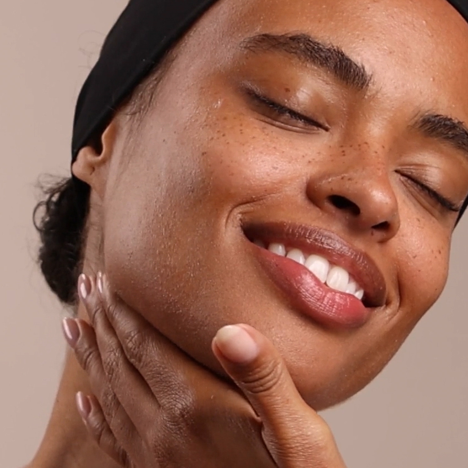 A woman applying Eminence Organics Bamboo Firming Fluid to face