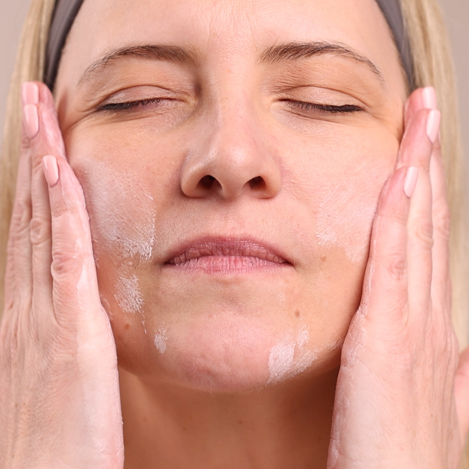 A woman applying the Eminence Organics Superfood Booster-Powder on her face