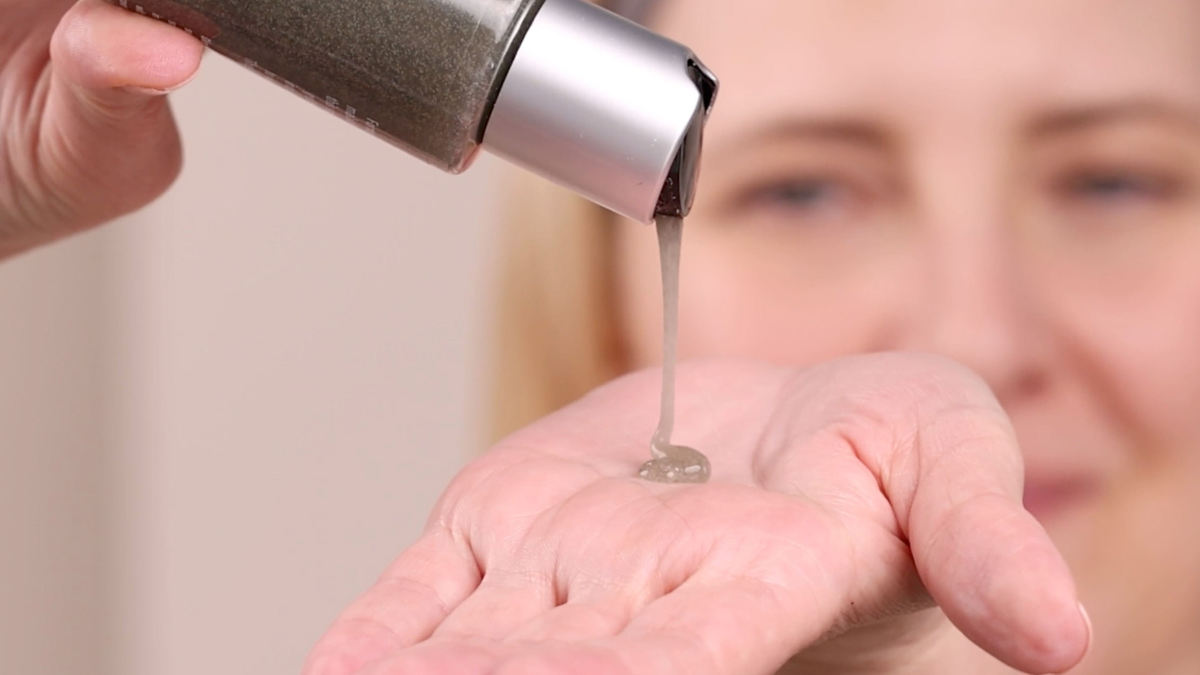 A woman applying Eminence Organics Charcoal Exfoliating Gel Cleanser to hand