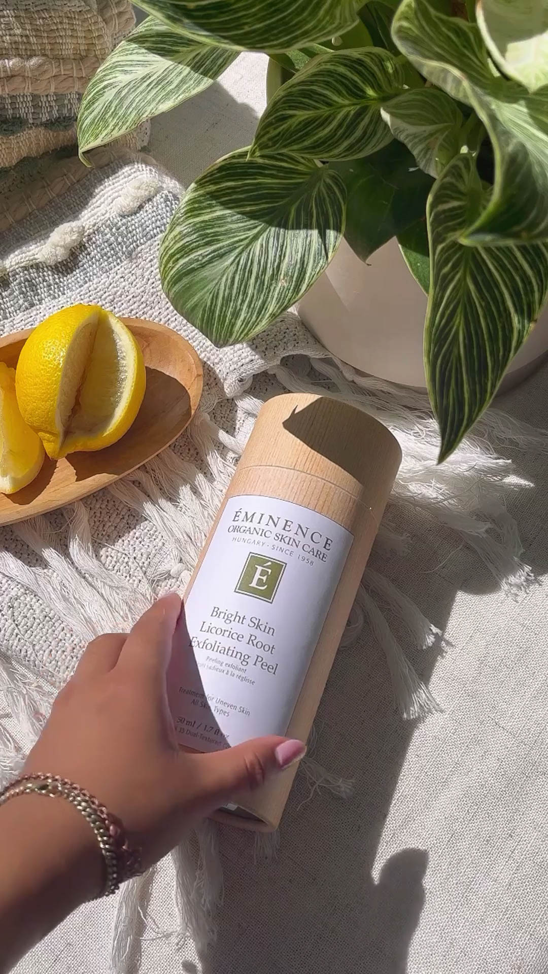 A woman holding Eminence Organics Bright Skin Licorice Root Exfoliating Peel