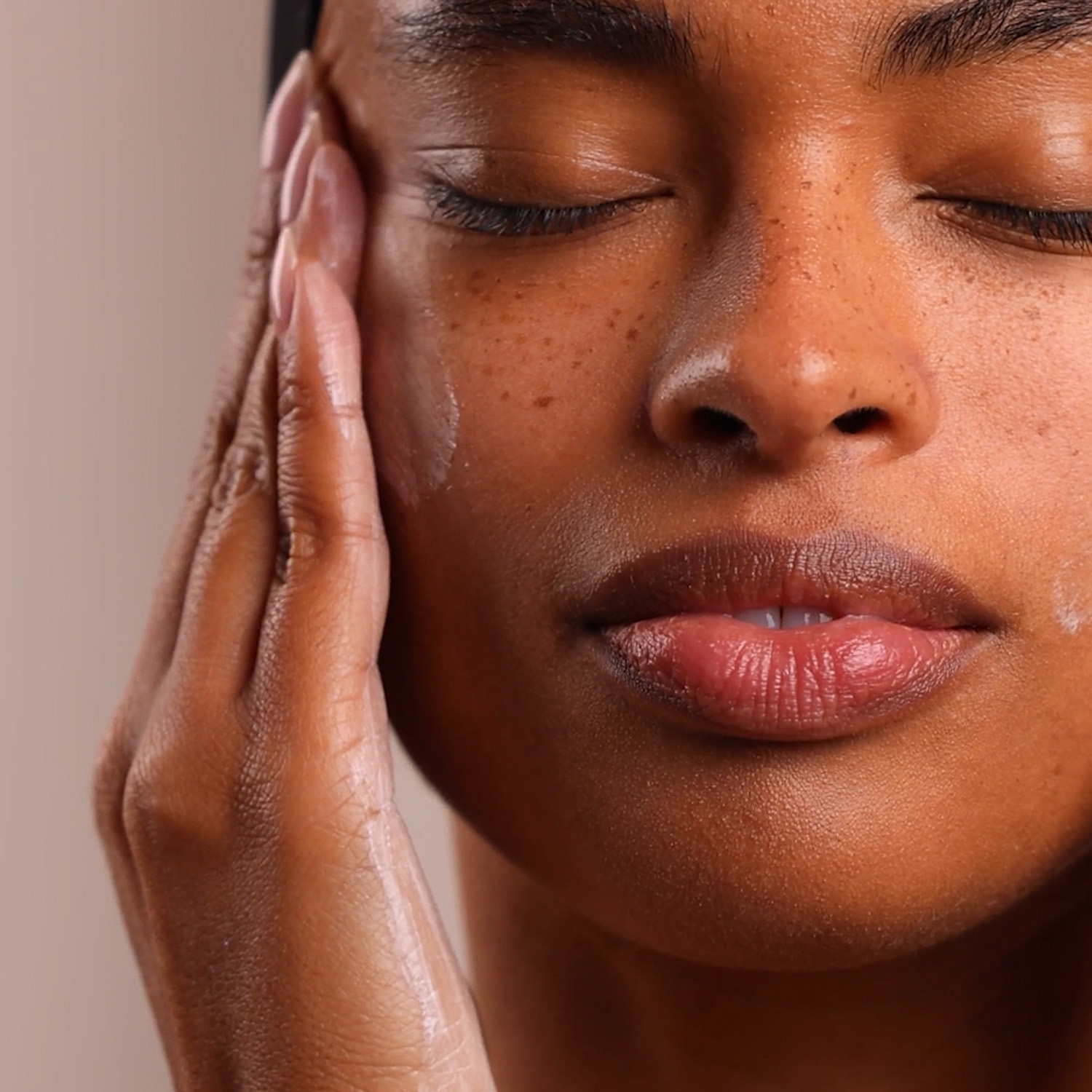 Woman applying Eminence Organics moisturizer to face