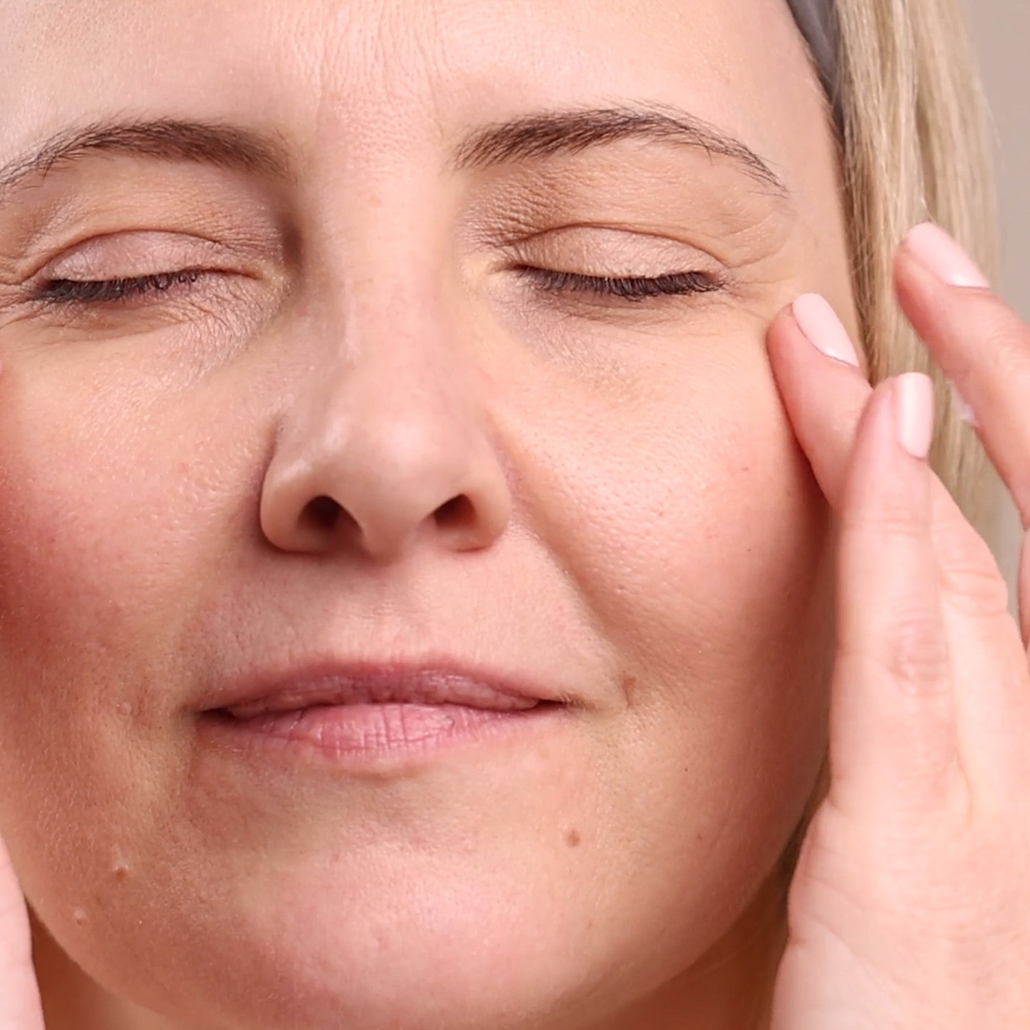 A woman applying the Eminence Organics Lavender Night Eye Cream to eye area