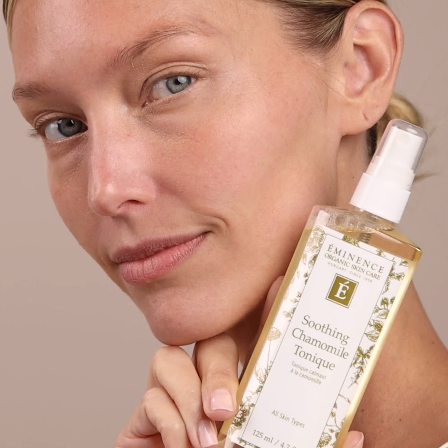A woman holding Eminence Organics Soothing Chamomile Tonique Swatch