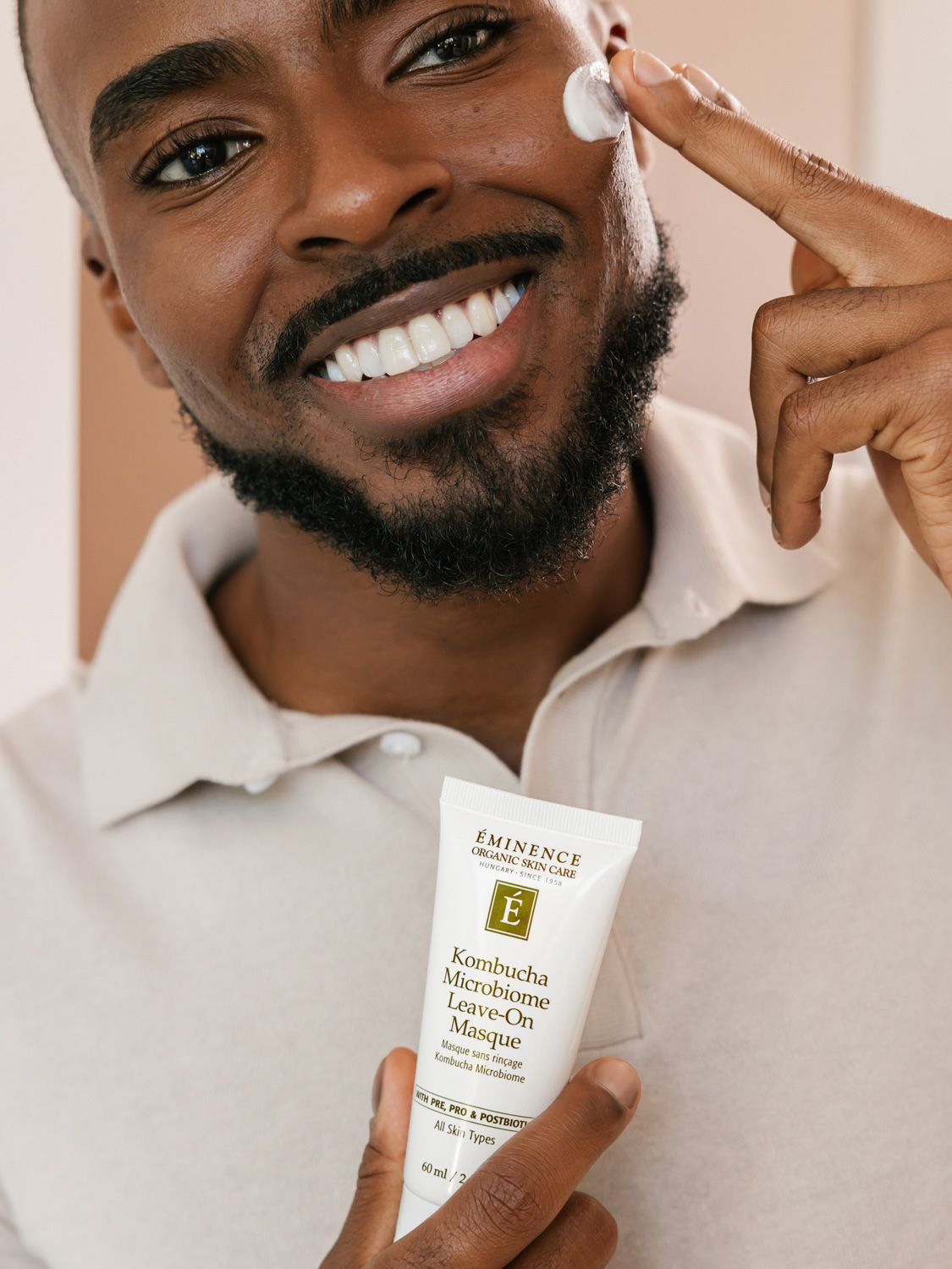 A man applying the Eminence Organics Kombucha Microbiome Leave-On Masque on his face
