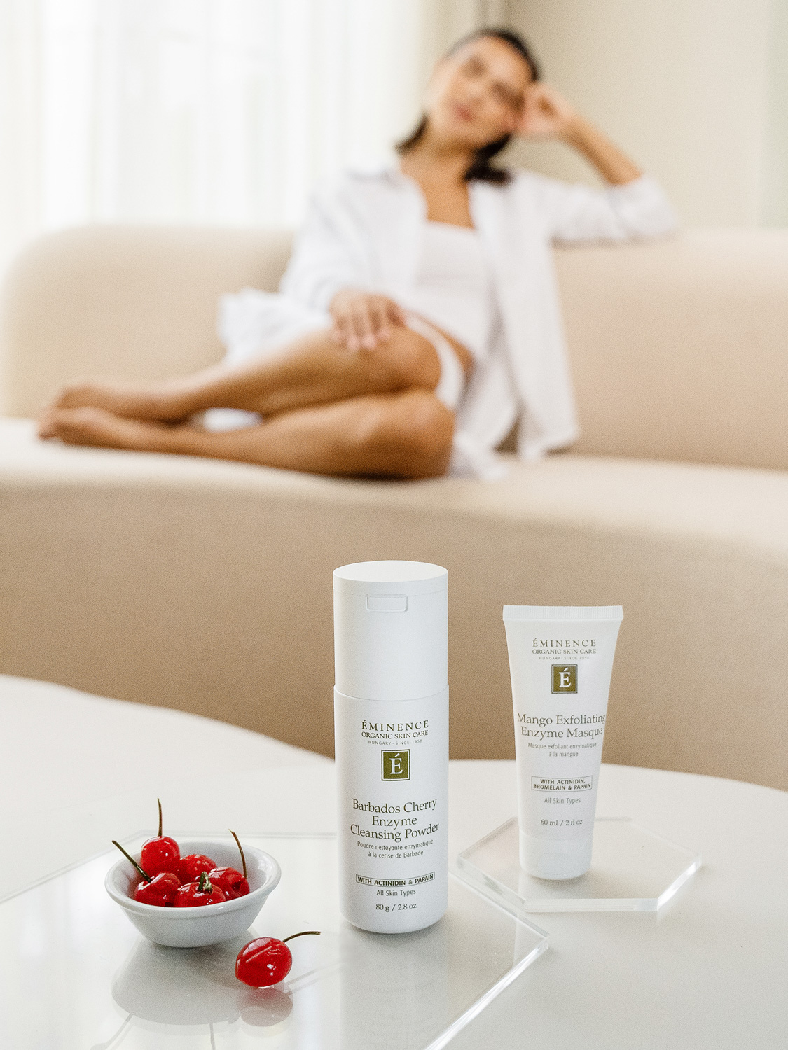 A woman sitting with Eminence Organics Barbados Cherry Enzyme Cleansing Powder
