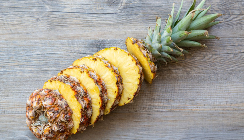 Pineapple sliced on cutting board