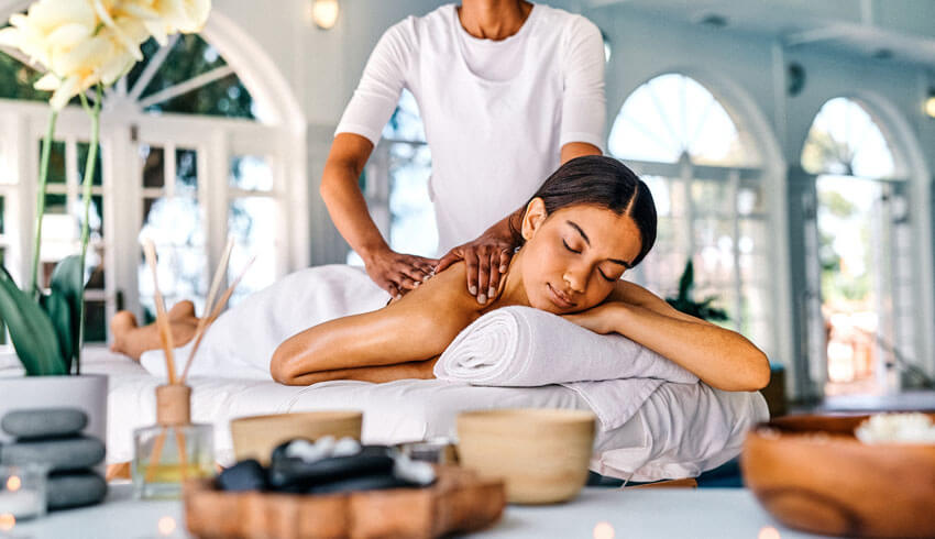 Woman relaxing on spa table with esthetician performing treatment