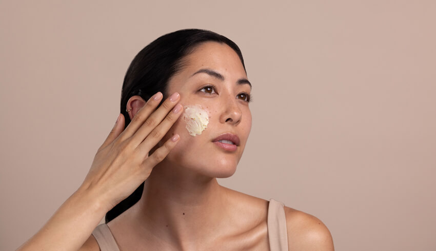 A woman applying moisturizer