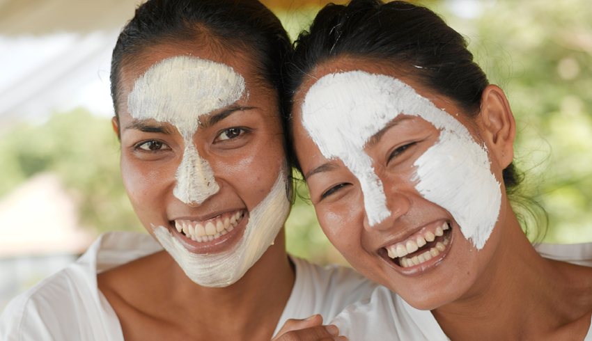 smiling women with clay face masks