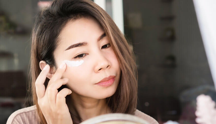 a woman applying eye cream