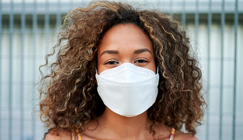 A woman wearing a surgical face mask. 