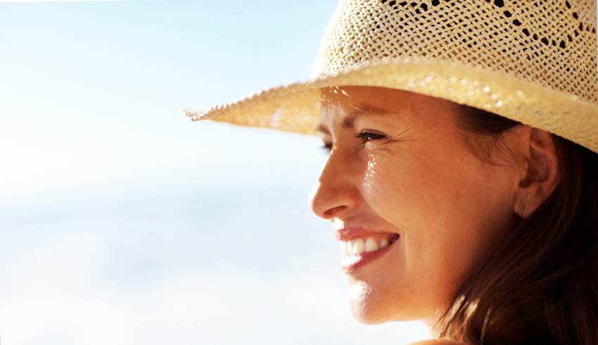 Woman with hat preventing dark spots on face
