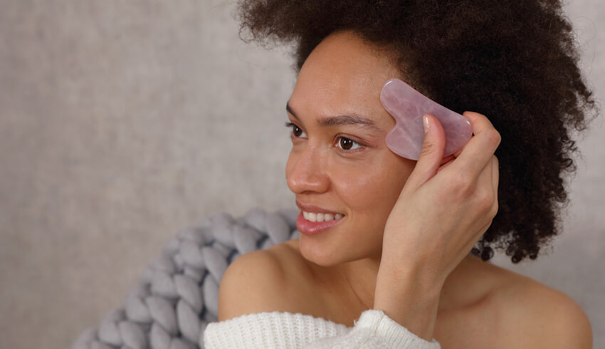 woman using a gua sha tool