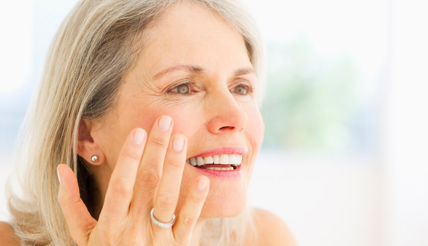 Mature woman checking for dark spots on face