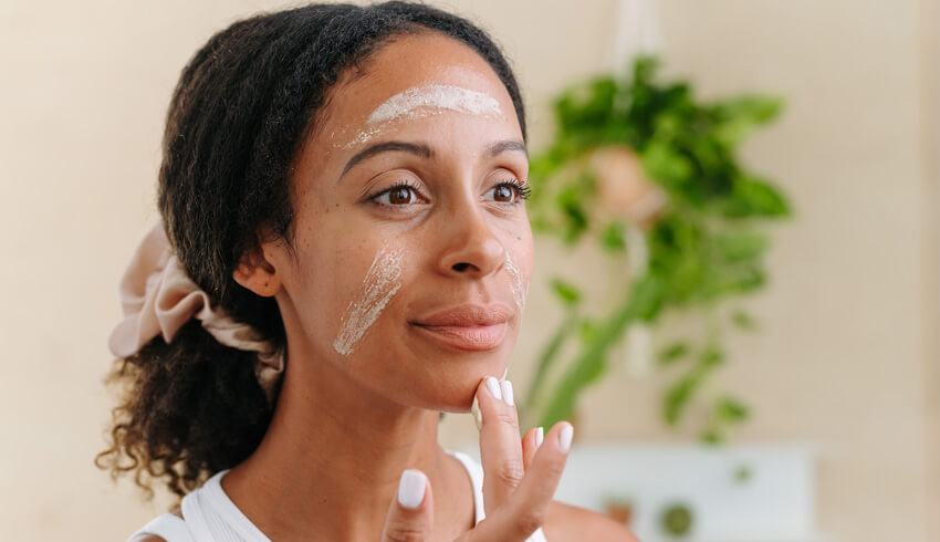 A woman applying skin care product