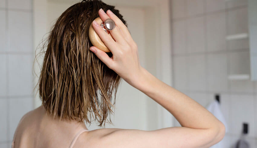 Woman massaging her head with scalp massager