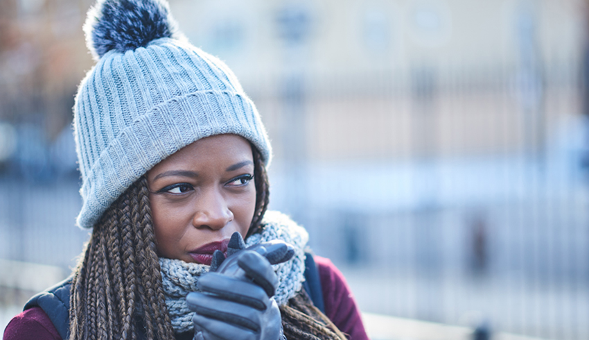 a woman appearing cold wearing a toque