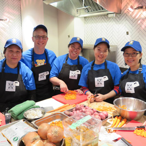 Eminence Organics team members chop vegetables to prepare meals as part of Soup Night