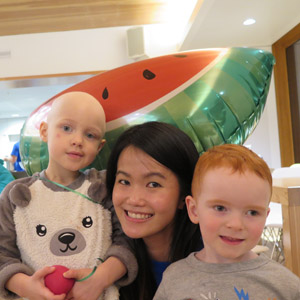 A Soup Night volunteer poses with two children at British Columbia Children's Hospital in Vancouver, Canada. 