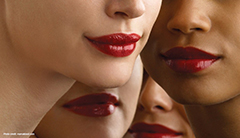 A close of the lips of four women wearing bright red lipstick. 